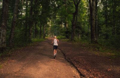 Runner Pauses At A Fork In A Sunlit Forest Path, Symbolizing The Choice Between A Long-term SEO Retainer And A Short-term ...