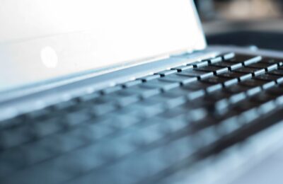 Close-up Of Modern House Keys Resting On A Sleek Laptop Keyboard, Symbolizing The Intersection Of Technology And The Real ...