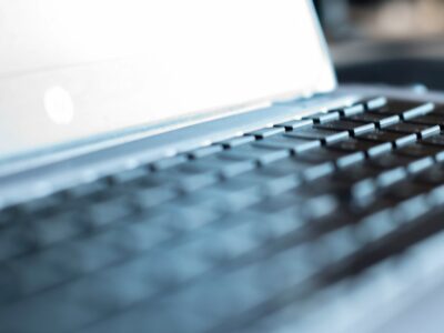 Close-up Of Modern House Keys Resting On A Sleek Laptop Keyboard, Symbolizing The Intersection Of Technology And The Real ...
