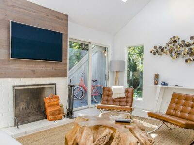Person Using A Laptop In A Bright, Modern Vacation Rental, Illustrating The Ease Of Managing A Direct Booking Website.