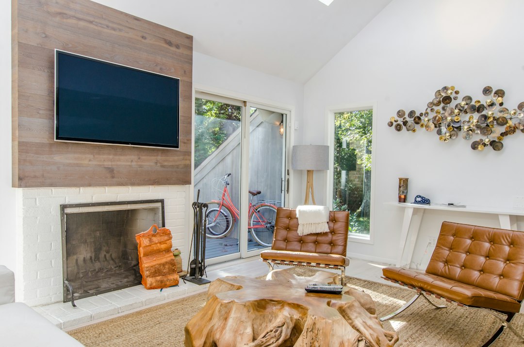 Person using a laptop in a bright, modern vacation rental, illustrating the ease of managing a direct booking website.
