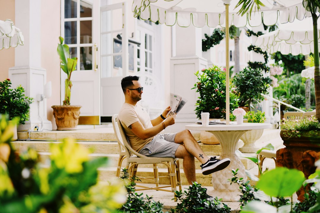 A professional vacation rental owner smiles while using a tablet on a modern patio, representing the control and success of a direct booking strategy.